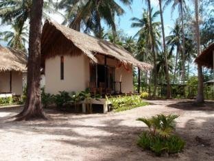 A bungalow with a shaded porch beside a sandy garden path at Angkana Hotel Bungalows