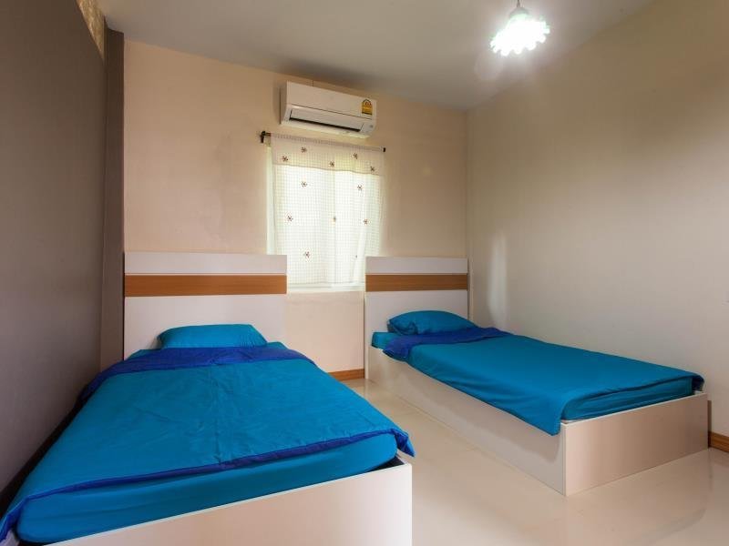 Twin beds with blue bedding in a room at At Phra Sing Guest House