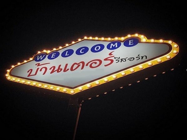 Illuminated welcome sign for Banter Resort at night