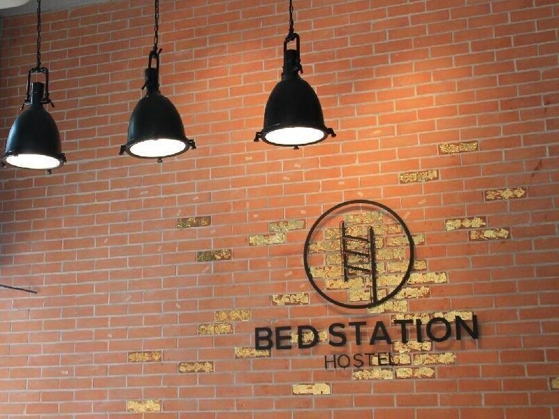 Brick-wall branding and pendant lights at BED STATION Hostel Ratchathewi