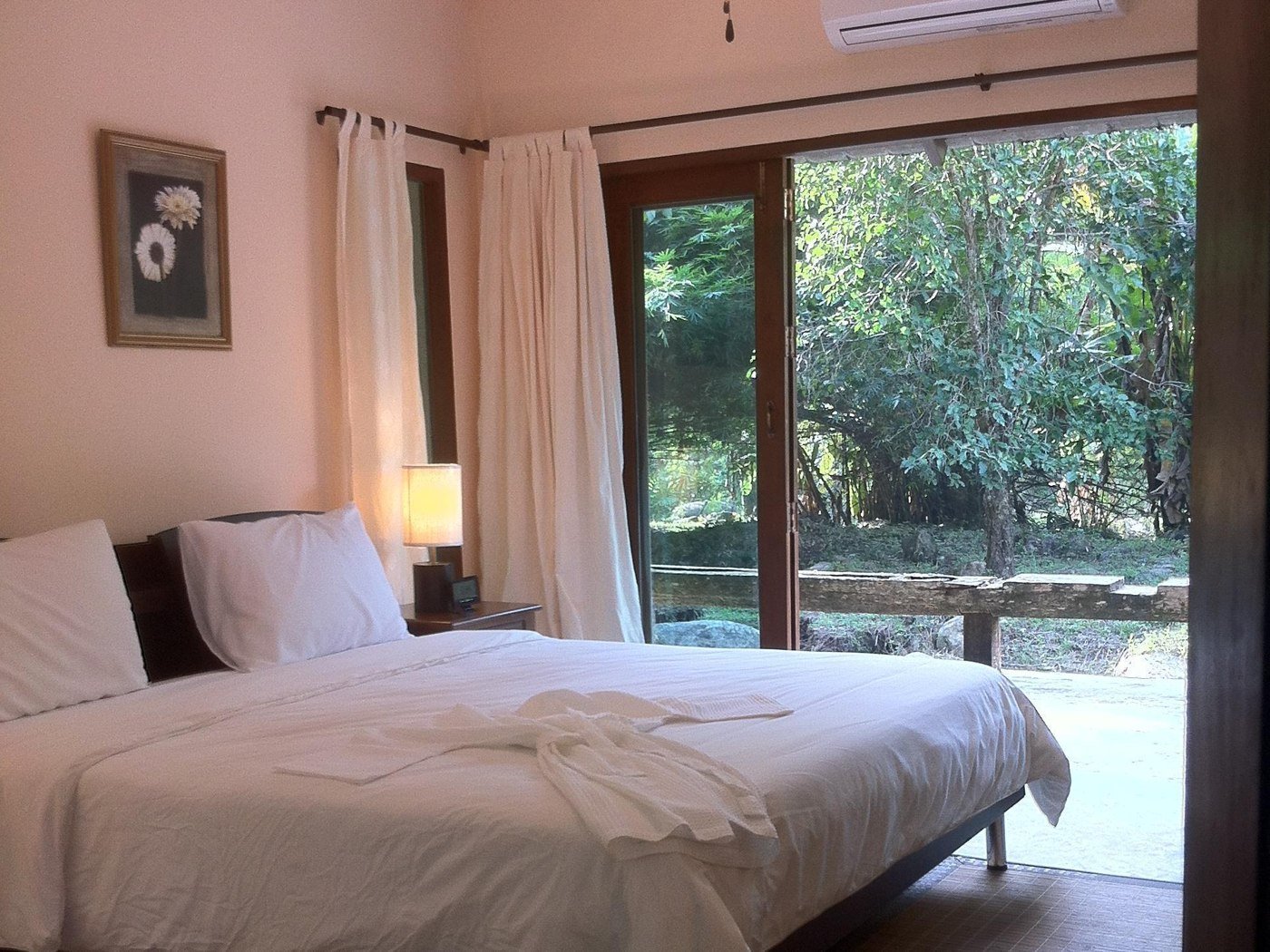 Double bedroom opening towards greenery at Charamai Resort