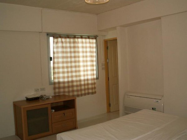 Simple bedroom with checked curtains and a television cabinet at Grandview Place