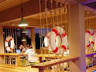 A colourful shared seating area with hanging ropes and decorative lifebuoys at Non La Mer Hostel