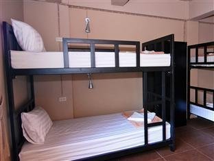 Black metal bunk beds with white bedding at Non La Mer Hostel