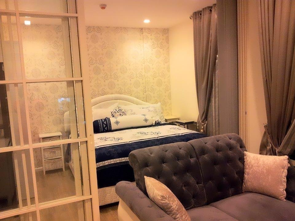 Sofa and bedroom separated by a glazed partition at Summer Hua Hin by Sirirat