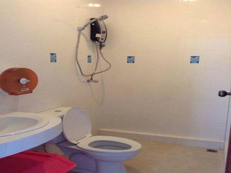 A bathroom with a wall-mounted shower, toilet and washbasin at The Best Hostel