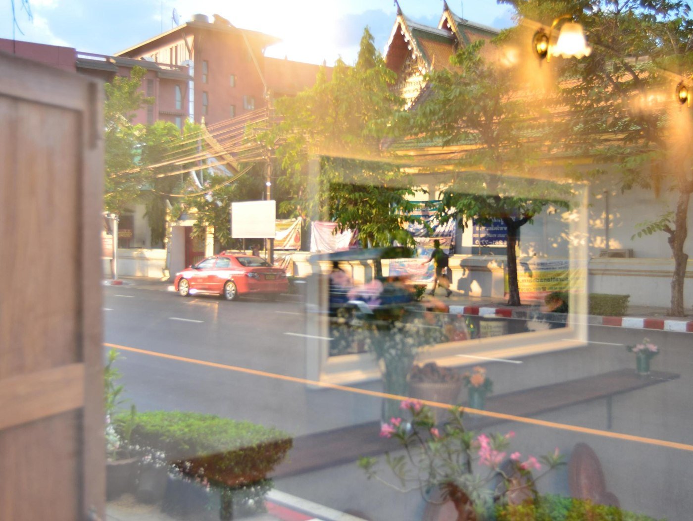 Street-side surroundings reflected in a Wayla Hostel window